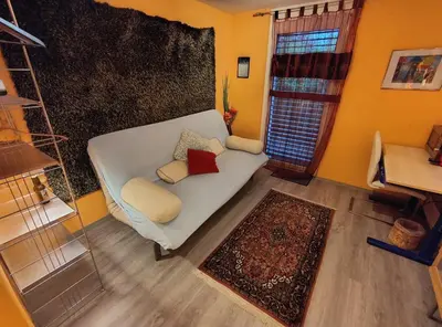 a living room with a white couch and a window at Zimmer oberhalb einer Schokoladenfabrik in Kreuzlingen