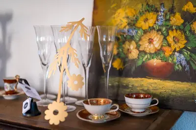 a table with two glasses and cups and a painting at Gasthaus zur Sonne - Hotel - Restaurant - Boutique in Gossau