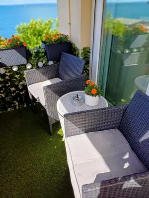a patio with a table and chairs and flowers at Studio Marylin in Rorschach