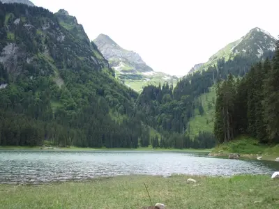 a lake in the middle of a valley with mountains at Modern trifft Tradition in Grabs