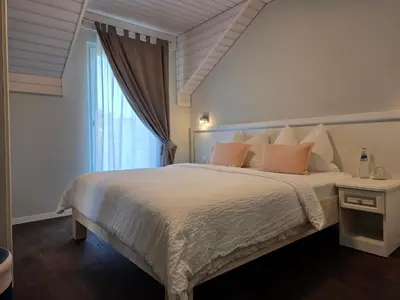 a bedroom with a large white bed with a window at Hotel Salvi in Kreuzlingen
