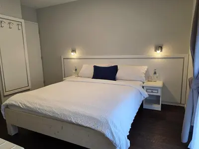 a bedroom with a large white bed with a blue pillow at Hotel Salvi in Kreuzlingen