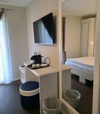 a room with a bathroom with a toilet and a tv at Hotel Salvi in Kreuzlingen