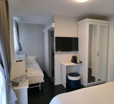 a room with a bed and a desk and a tv at Hotel Salvi in Kreuzlingen