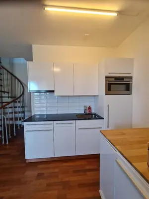 a kitchen with white cabinets and a counter top at Maisonette-Wohnung inmitten der Natur in Wald