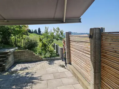 a woman standing next to a wooden fence at Maisonette-Wohnung inmitten der Natur in Wald