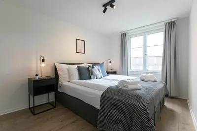 a bedroom with a large bed and a window at book2stay - Apartments Spisertor in St. Gallen