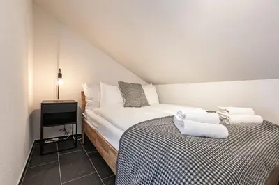 a bedroom with two beds in a attic at book2stay - Apartments Spisertor in St. Gallen