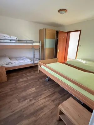 a room with two bunk beds and wooden floors at Bergnest Wildhaus in Wildhaus