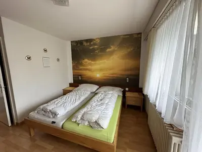 a bedroom with a bed with a painting on the wall at Bergnest Wildhaus in Wildhaus