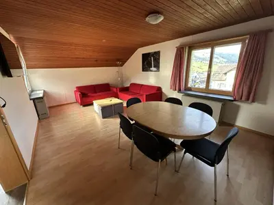 a living room with a table and chairs and a couch at Bergnest Wildhaus in Wildhaus