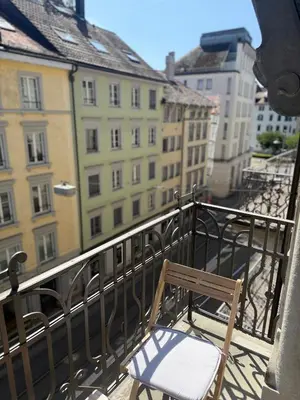 a chair sitting on top of a balcony with buildings at Studio mit Balkon im Zentrum in St. Gallen