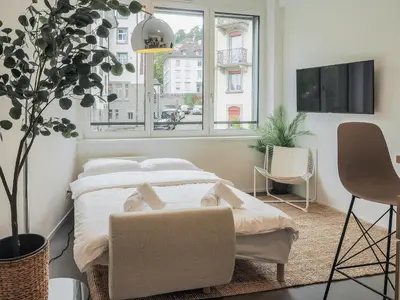 a bedroom with a bed and a large window at WYBA Living - Modernes Apartment - Gratis ÖV - Ruhig & Zentral in St. Gallen