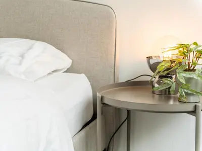 a bed and a side table next to a bed at WYBA Living - Modernes Apartment - Gratis ÖV - Ruhig & Zentral in St. Gallen