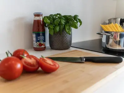 a cutting board with tomatoes and a knife on a counter at WYBA Living - Modernes Apartment - Gratis ÖV - Ruhig & Zentral in St. Gallen