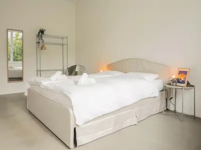 a large white bed with white sheets and pillows at WYBA Living - Modernes Apartment - Gratis ÖV - Ruhig & Zentral in St. Gallen