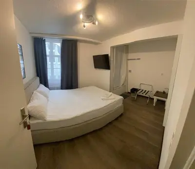 a bedroom with a white bed and a shower at Kränzlin Hotel in St. Gallen