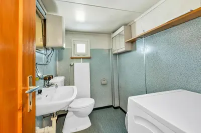 a small bathroom with a toilet and a sink at romatisches Chalet mit Bodenseesicht in Wolfhalden