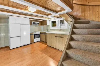 a kitchen with a staircase leading up to a kitchen at romatisches Chalet mit Bodenseesicht in Wolfhalden
