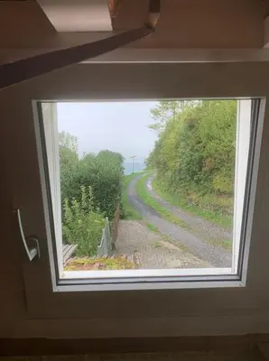 a window in a house looking out at a road at romatisches Chalet mit Bodenseesicht in Wolfhalden