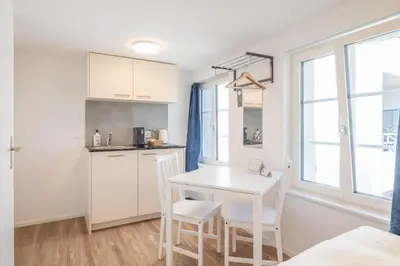 a kitchen with a white table and chairs in a room at CasaMia Flawil in Flawil
