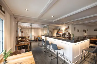 a room with a bar with chairs and tables at CasaMia Flawil in Flawil