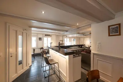 a kitchen with a counter and chairs in a room at CasaMia Flawil in Flawil