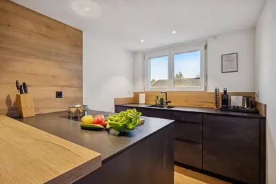 a kitchen with a table and chairs and a counter at Suite4you Erlen l Privater Pool ganzjährig beheizt & Sauna l 10min zum Bodensee, Parkplatz & WLAN in Erlen