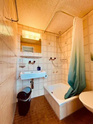 a bathroom with a tub and a sink at Dreibettzimmer mit eigenem Bad und Seeblick in Heiden