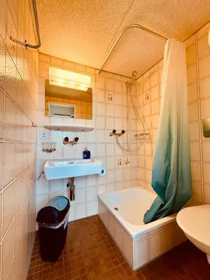 a bathroom with a tub and a sink at Dreibettzimmer mit eigenem Bad und Seeblick in Heiden