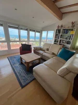 a living room with a couch and a table at Holiday home with pool & dream view over Lake Constance in Rorschacherberg