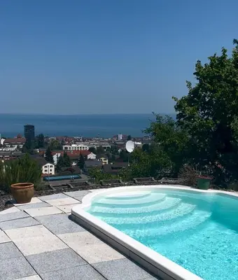 a swimming pool with a view of a city at Holiday home with pool & dream view over Lake Constance in Rorschacherberg