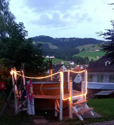 a wooden boat with lights in a yard at SwissCottages Blockhaus in Schönengrund