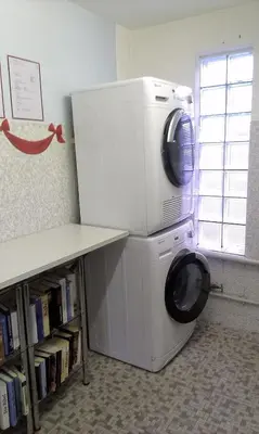 a washing machine with a microwave on top of it at SwissCottages Blockhaus in Schönengrund