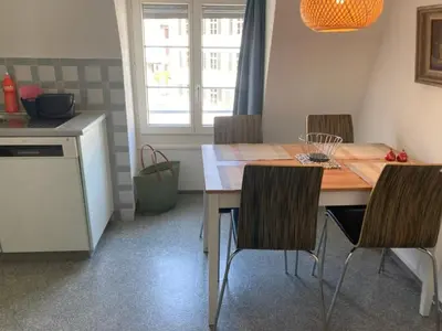 a kitchen with a wooden table with chairs and a counter at Euer Domizil im Herzen von Altstätten SG, Schweiz in Altstätten