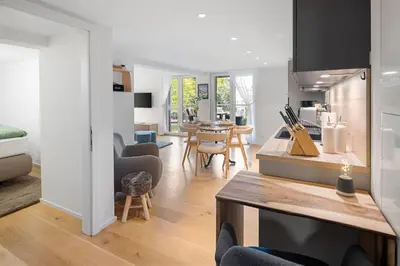 a kitchen and living room with a table and chairs at Modernes Apartment mit Balkon und Parkplatz, Nähe See in St. Gallen