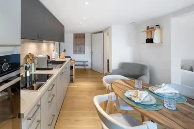 a kitchen and dining room with a table and chairs at Modernes Apartment mit Balkon und Parkplatz, Nähe See in St. Gallen