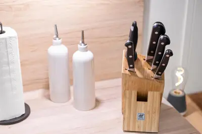 a knife block with two white bottles on a table at Modernes Apartment mit Balkon und Parkplatz, Nähe See in St. Gallen