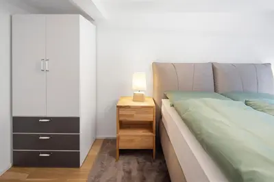 a bedroom with a bed and a nightstand with a lamp at Modernes Apartment mit Balkon und Parkplatz, Nähe See in St. Gallen