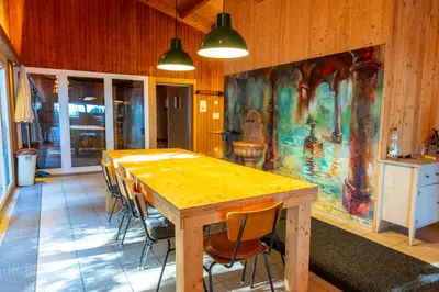 a wooden table in a room with a painting on the wall at Seesicht - Rückzugsort oberhalb vom Bodensee in Wienacht-Tobel