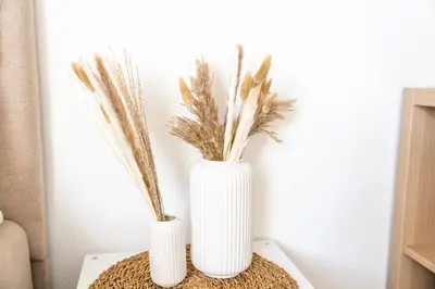 two white vases with plants in them on a table at Seesicht - Rückzugsort oberhalb vom Bodensee in Wienacht-Tobel