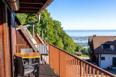a balcony of a house with a table and chairs at Seesicht - Rückzugsort oberhalb vom Bodensee in Wienacht-Tobel