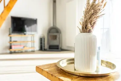 a white vase on a plate on a table at Seesicht - Rückzugsort oberhalb vom Bodensee in Wienacht-Tobel