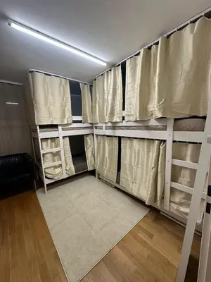 a room with bunk beds with curtains and a rug at Hostel I Love Sg in St. Gallen