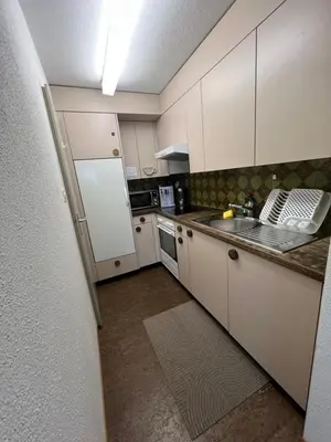 a kitchen with white cabinets and a white refrigerator at Hostel I Love Sg in St. Gallen