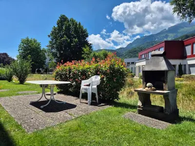a table and a table and a grill in a yard at SwissRest - Self Check-In in Sevelen