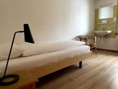 a bedroom with a bed with a lamp and a sink at Krone Trogen in Trogen