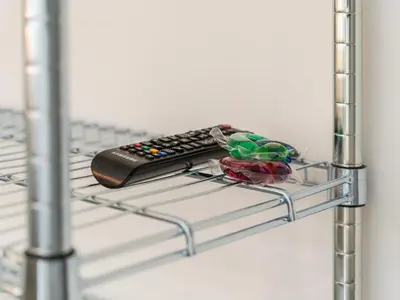 a remote control sitting on a metal shelf at Modernes Hostel, Privatzimmer in Shared Apartment, WYBA Living in St. Gallen