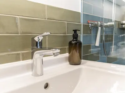 a bathroom sink with a soap bottle on it at Modernes Hostel, Privatzimmer in Shared Apartment, WYBA Living in St. Gallen