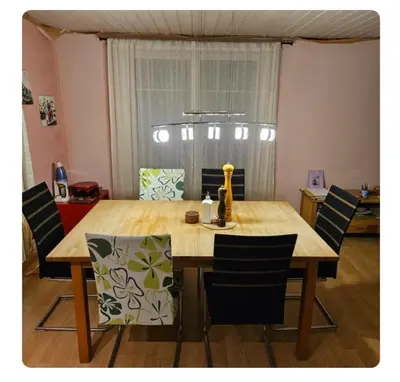 a dining room table and chairs with a wooden table and a table and chairsktop at Holzchalet mit Garten und Terrasse in Egnach